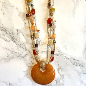 Gold tone beaded necklace with large stone pendant